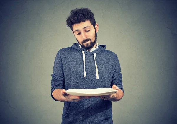 Man with empty plate looking sad — Stock Photo, Image
