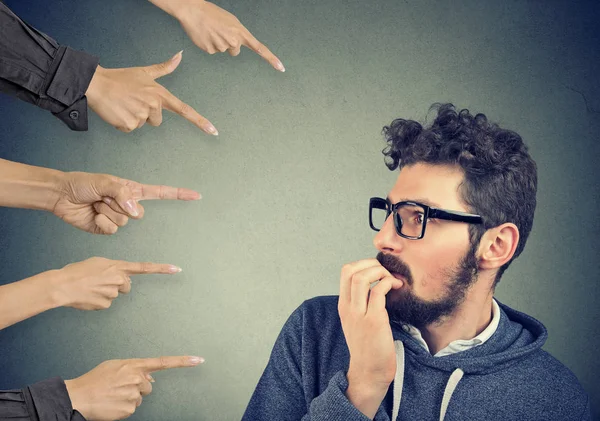 Anxious man judged by different hands. Concept of accusation of guilty guy. — Stock Photo, Image