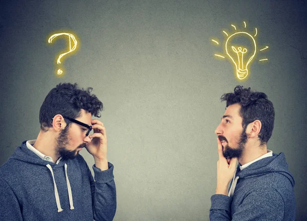 Dois homens pensando que um tem uma pergunta outra solução com lâmpada acima da cabeça — Fotografia de Stock