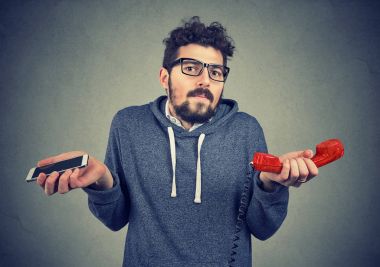 Eski moda ve çağdaş araçlar hakkında şaşkın bakan adam. 