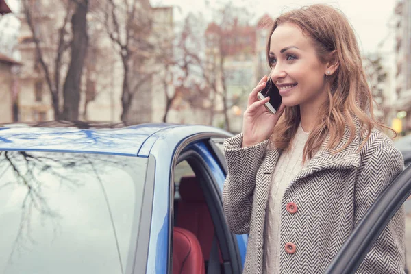 Νεαρή γυναίκα οδηγός μιλάει στο τηλέφωνο έξω από — Φωτογραφία Αρχείου