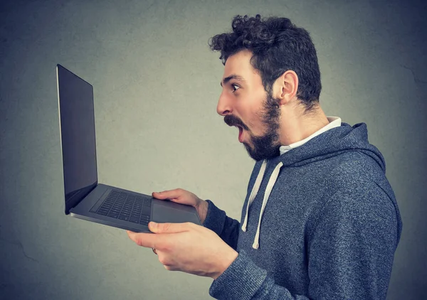 Sorprendido hombre feliz viendo nuevo ordenador portátil — Foto de Stock