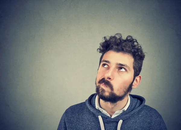 Suspicious young man looking up — Stock Photo, Image