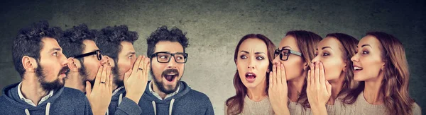 Group of young men and women whispering each other in the ear — Stock Photo, Image