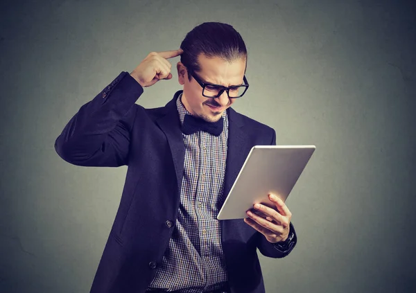 Homem confuso assistindo tablet em cinza — Fotografia de Stock