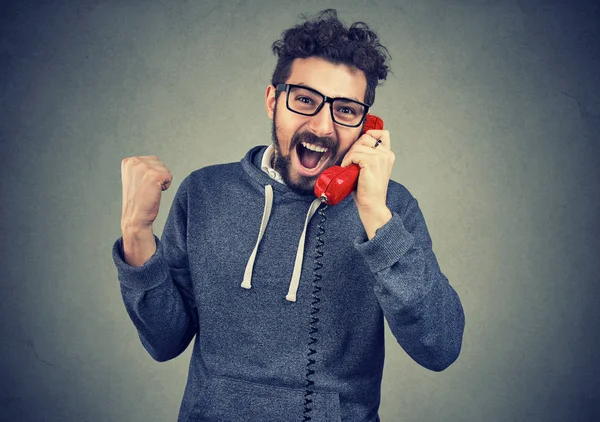 Homem animado recebendo boas notícias em um telefone — Fotografia de Stock