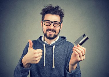 man holding a credit card showing thumbs up clipart