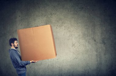 büyük bir kutu taşıyan adam