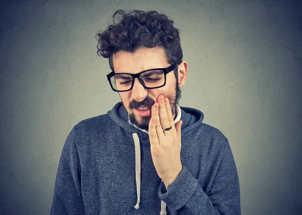 Uomo con mal di denti che soffre di dolore, toccando la bocca esterna con mano — Foto Stock