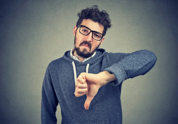 Hombre en gafas que muestran aversión con el gesto del pulgar hacia abajo — Foto de Stock