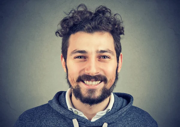 Hipster uomo in felpa grigia sorridente felicemente alla macchina fotografica . — Foto Stock