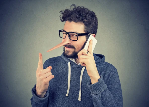 Sly kłamca człowiek z długim nosem rozmowy na telefon komórkowy — Zdjęcie stockowe