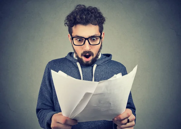 Homme excité regardant des documents en état de choc — Photo