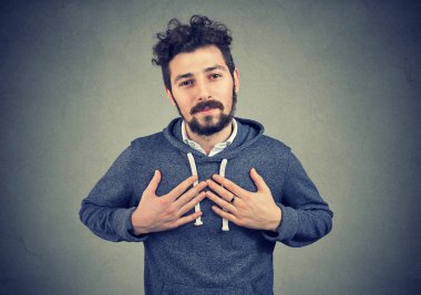 Faithful man keeps hands on chest near heart, shows kindness expresses sincere emotions clipart