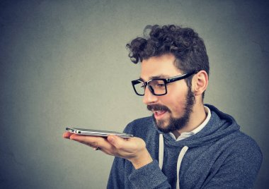 Hipster adam gözlüklü bir akıllı telefon ses tanıma işlevini kullanma