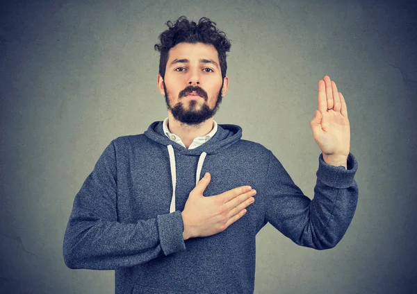 Sincere man swearing with hand on heart — Stock Photo, Image