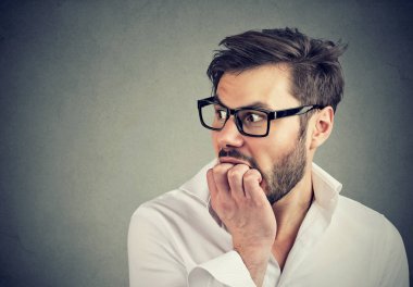 Meşgul endişeli erkek tarafına bakarak tırnaklarını ısırma 