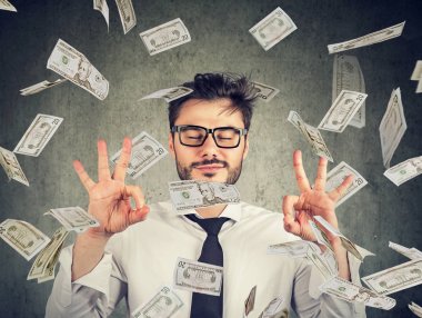 Business man meditating under money rain clipart