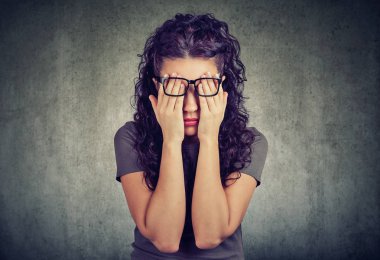 iki eliyle yüzünü gözler kapsayan bardaklarda genç kadın