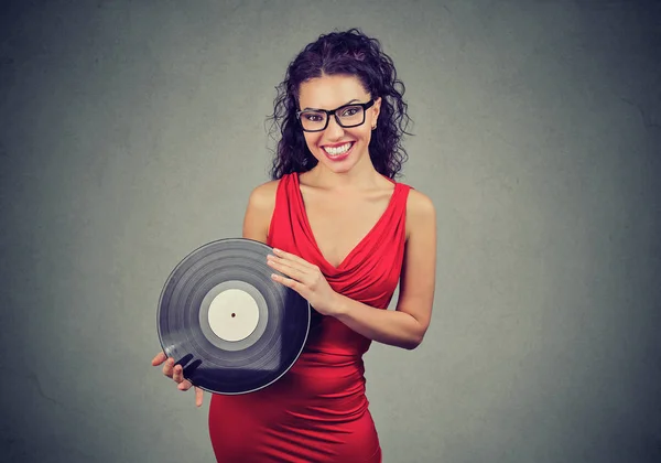 Sorridente bella giovane donna che mostra un vinile vintage — Foto Stock