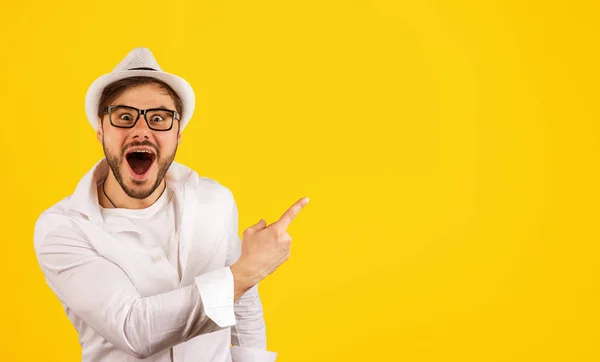 Feliz hipster apuntando hacia el amarillo — Foto de Stock