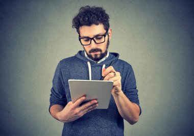 Tablet bilgisayar kullanan ciddi hipster adam 