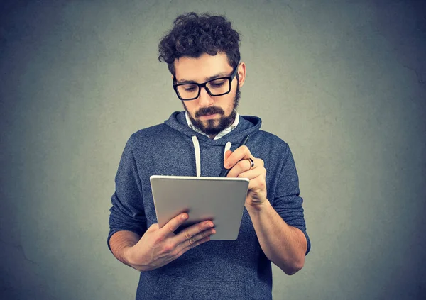 Homme hipster sérieux utilisant un ordinateur tablette — Photo