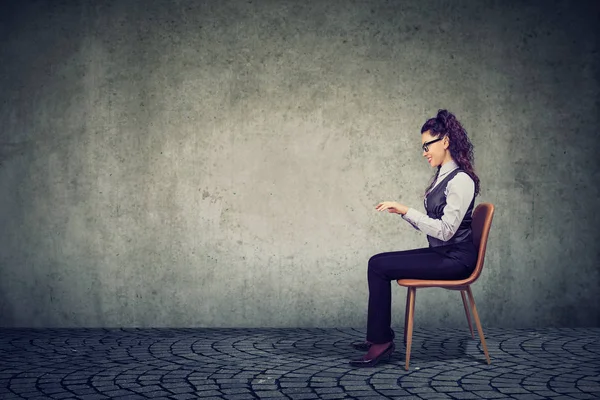 Woman sitting at imaginary table — Stock Photo, Image