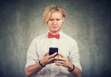 Kafası karışmış bir adamın portresi. Akıllı telefonuyla kötü haberler okuyor. 