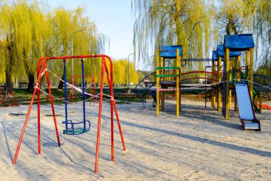 Coronavirus 'un neden olduğu COVID-19 salgınının karantina döneminde ziyaret edilmesi yasak olan kırmızı ve beyaz bantlarla sarılı boş bir oyun alanı.