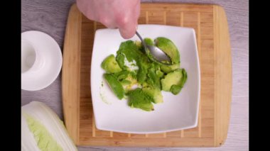 Avokado, yumurta, sığır eti, marul, krem peynir soslu Meksika dürümü pişirip buğday tortilla yapıyorum. Bambu tahtasından yapılmış. Çerçevede sadece eller var. Üst Manzara. Yemek tarifi. Zaman Uygulaması.