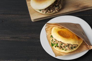 Tahta bir masada Rou jia mo Çin hamburgeri.