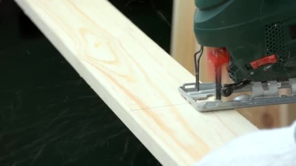 Dieses Video zeigt, wie eine Stichsäge verwendet wird, um eine Holzplanke zu schneiden. — Stockvideo