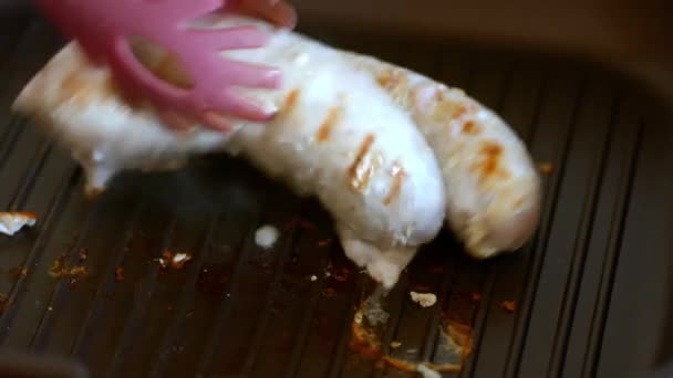 Смажені м'ясні свинячі та яловичі ковбаски на сковороді . — стокове відео