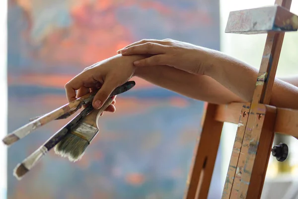 Artist\'s hand with brushes for painting with blur background
