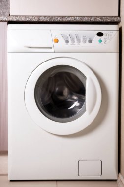 Mutfakta beyaz çamaşır makinesi var.