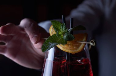 Kırmızı kokteyl hazırlıyorum. İnsan kaynakları barında eller.