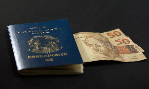 在黑暗背景下旅行的基本物品 巴西护照和巴西货币 — 图库照片