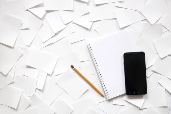 notebook with a phone and a pencil on a white background