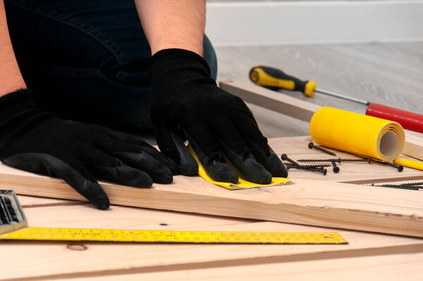 The guy is sanding wooden boards. DIY photophone. 