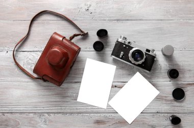 Eski kamera, filmler ve fotoğraflar gri ahşap bir masada yatıyor. Model.