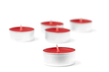 Beyaz arka planda küçük kırmızı kokulu mumlar. Aroma terapisi.