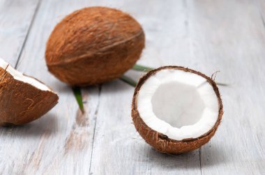 Gri ahşap bir masada hindistan cevizi. Yarım hindistan cevizi.