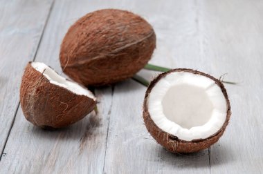 Gri ahşap bir masada hindistan cevizi. Yarım hindistan cevizi.