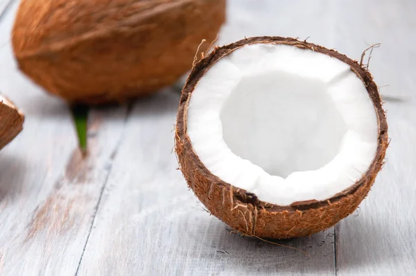 Gri ahşap bir masada hindistan cevizi. Yarım hindistan cevizi.