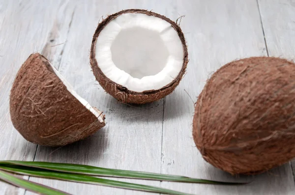 Gri ahşap bir masada hindistan cevizi. Yarım hindistan cevizi.