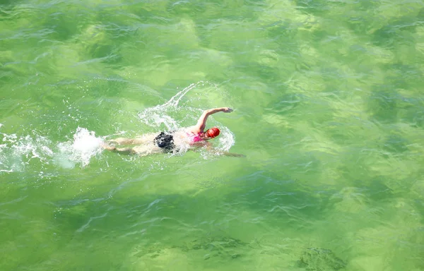Пловчиха в плавательной шапочке, тренирующаяся в прекрасном океане. — стоковое фото