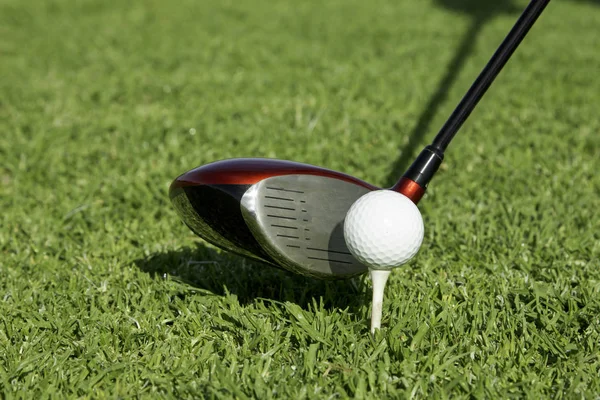 Golfboll på tee framför en drivrutin — Stockfoto