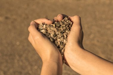 Elleriniz ve taş kalp simgesi