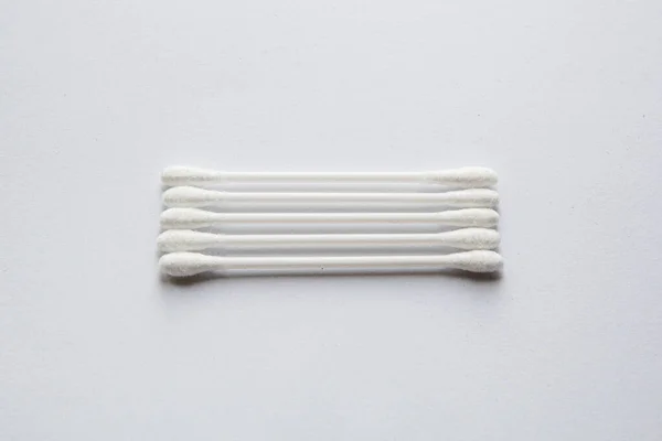 Beyaz arka planda duran kulak çubuklarının üst görünümü hizada uzanır